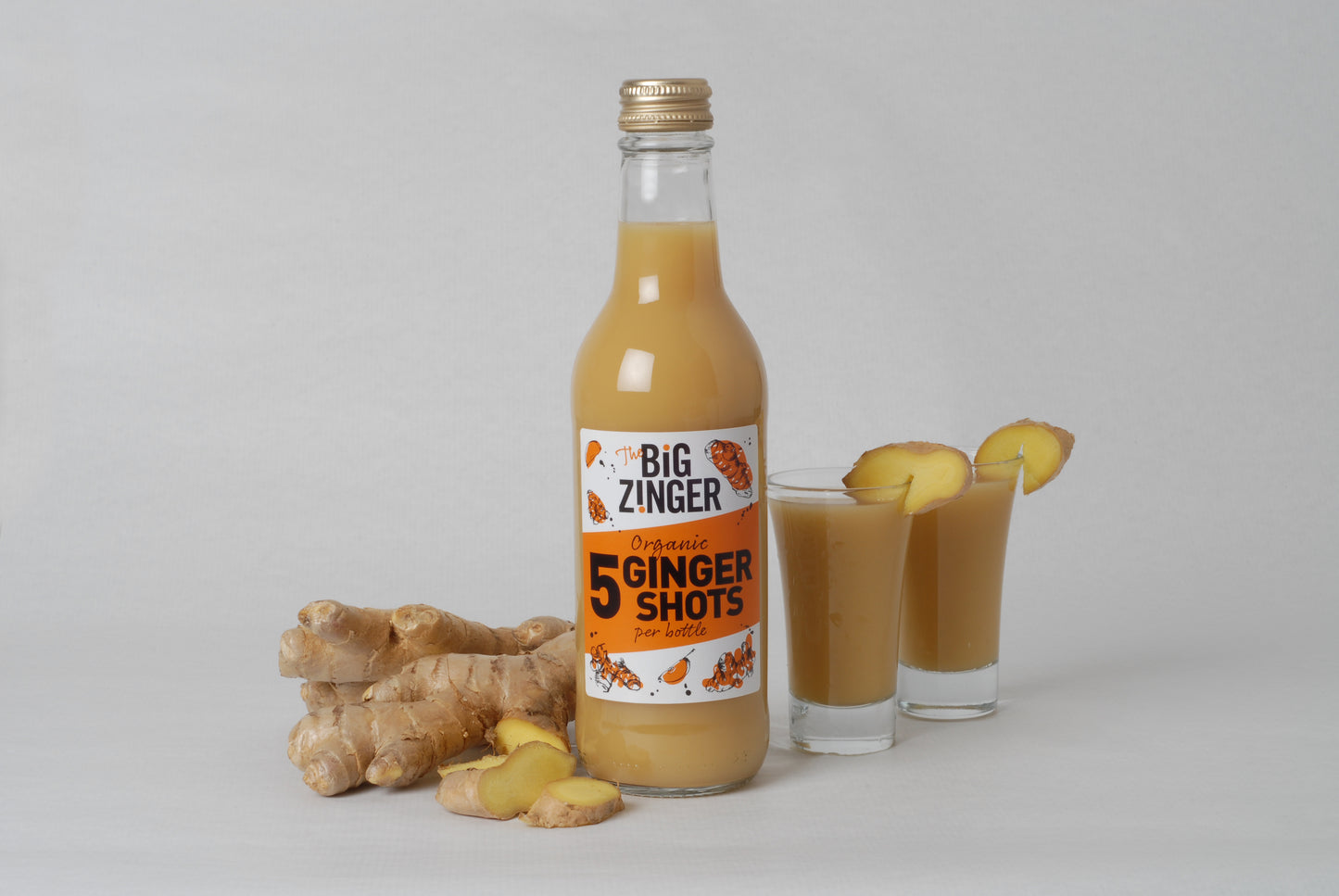 Organic Ginger Zinger dosing bottle with two shots poured into glasses