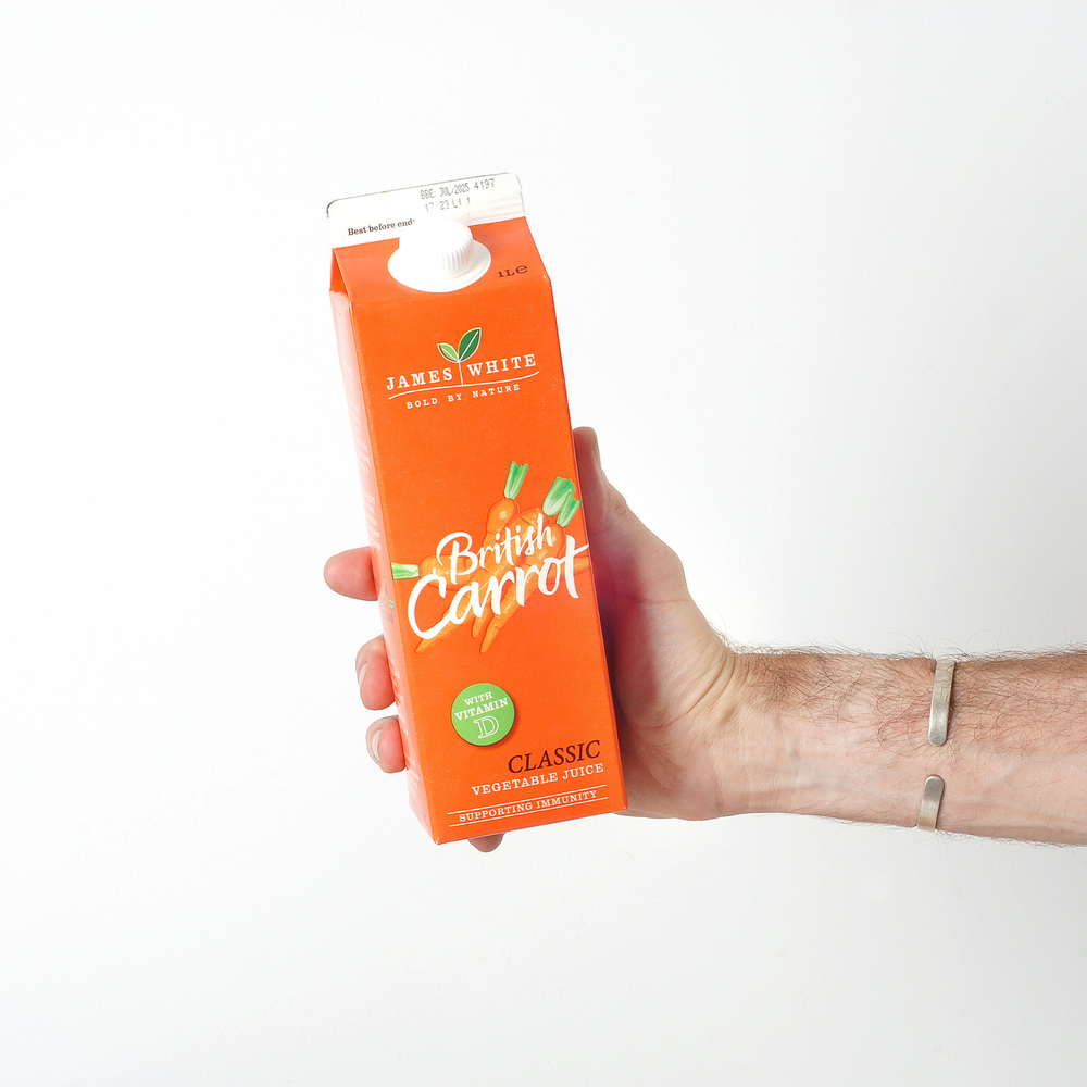 
                  
                    Hand holding a carton of British Carrot juice
                  
                